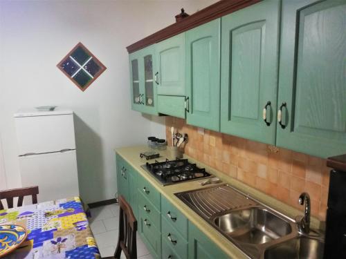 a kitchen with green cabinets and a sink at Casa Vacanza NINA in Milazzo