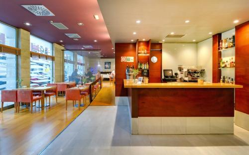 アビレスにあるOca Villa de Avilés Hotelのバー、テーブルと椅子付きのレストランを提供しています。