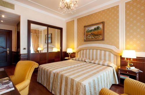 a hotel room with two beds and two lamps at Grand Hotel Bristol in Stresa