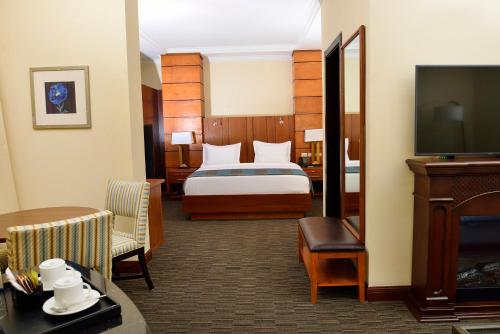 um quarto de hotel com uma cama e uma televisão de ecrã plano em The HUB Hotel em Addis Ababa