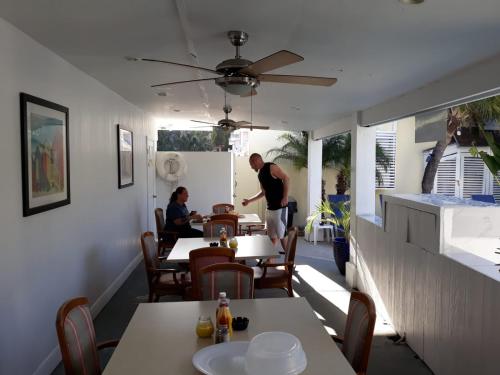 a man standing at a table in a restaurant at Sandelwood Studios' in Nassau