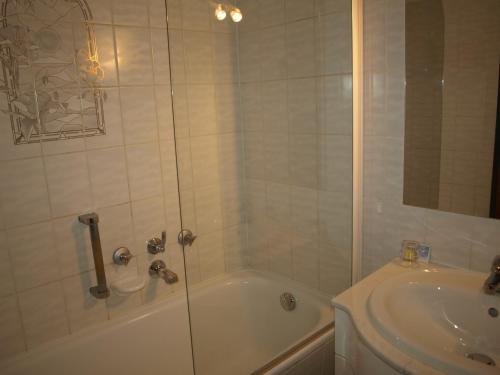 y baño con ducha, bañera y lavamanos. en Hotel Villa Sulmana, en Neckarsulm