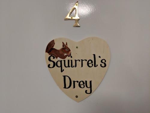 a heart shaped sign that reads squirrels drip at Barholm Accommodation in Creetown