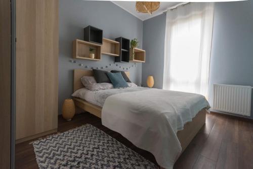 ein Schlafzimmer mit einem großen Bett mit blauen Wänden in der Unterkunft NAP Apartments Mila Baltica gym&sauna in Danzig
