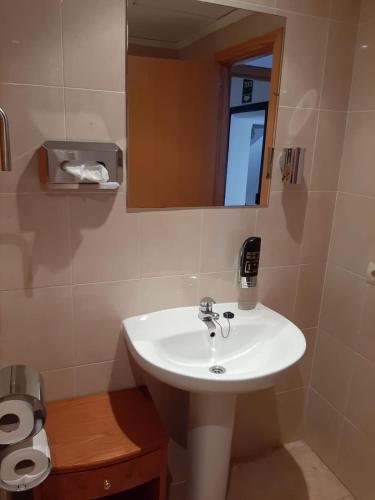 a bathroom with a white sink and a mirror at Hostal Tierramar in El Arenal