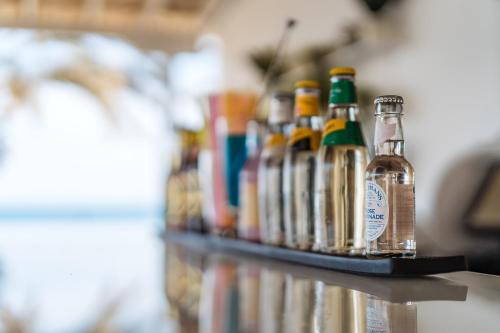 a row of bottles of alcohol sitting on a shelf at Vrachia Beach Hotel & Suites - Adults Only in Paphos City