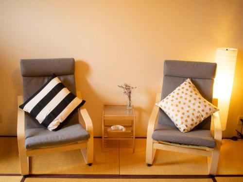 two chairs sitting next to each other in a room at SLOW HOUSE NARA in Nara