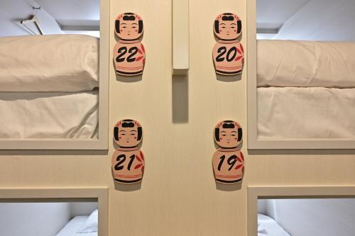 a wall with a picture of a person with the number twentytwo at Hotel Tomariya Ueno in Tokyo