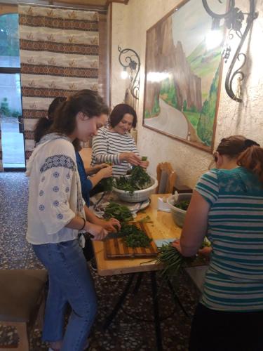 a group of women standing around a table preparing food at Kirch Hotel & Restaurant in Goris