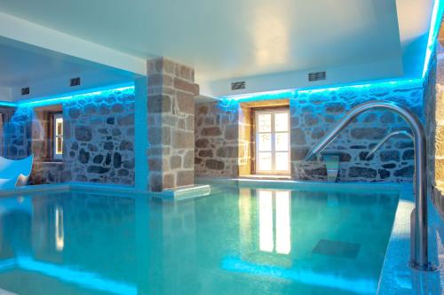 a swimming pool in a house with blue lighting at Convento do Seixo Boutique Hotel & Spa in Fundão