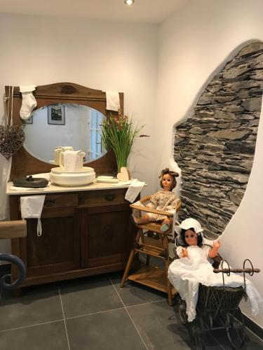 twee poppen in een badkamer met een spiegel bij Hotel Klapperburg in Beilstein