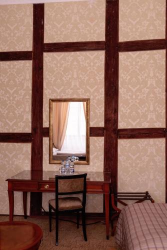 a bedroom with a mirror and a desk with a chair at Pałac Brody in Brody