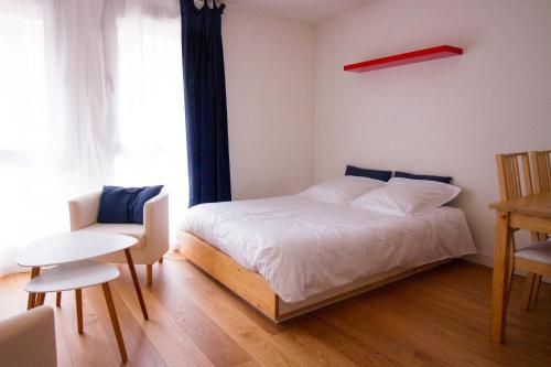 リールにあるStudioLille - Saint Michelのベッドルーム1室(ベッド1台、椅子、窓付)
