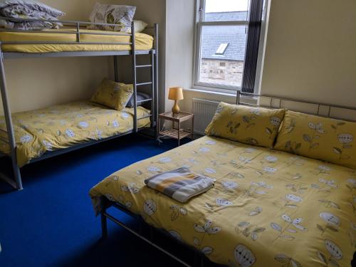 a bedroom with bunk beds and a bed with a couch at Barholm Accommodation in Creetown