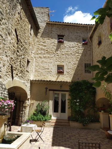a stone building with a door and a patio at Le Térébinthe B&B in Lauris