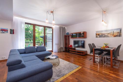Beachfront Apartment Haga with Free Parking by Renters في سوبوت: غرفة معيشة مع أريكة زرقاء وطاولة