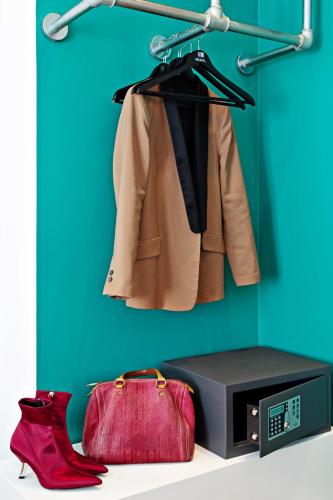 a coat and a toaster and a red bag next to acomputer at One Shot Prado in Madrid
