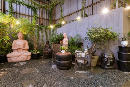 a courtyard with statues and plants in a building at Dragonfly Hotel - The Art Hotel in Mumbai