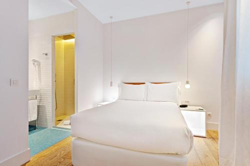 a white bedroom with a white bed and a bathroom at One Shot Prado in Madrid