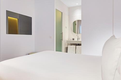 a white bathroom with a sink and a mirror at One Shot Prado in Madrid