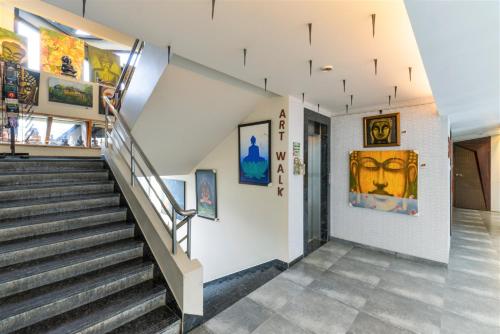 a staircase in a building with paintings on the walls at Dragonfly Hotel - The Art Hotel in Mumbai