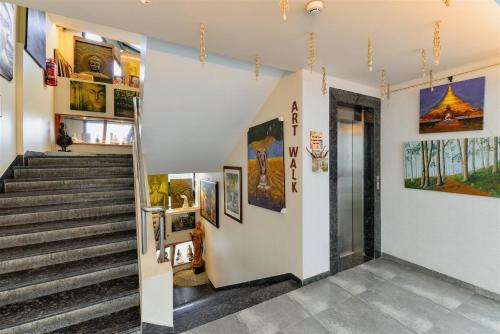 a staircase in a building with paintings on the walls at Dragonfly Hotel - The Art Hotel in Mumbai