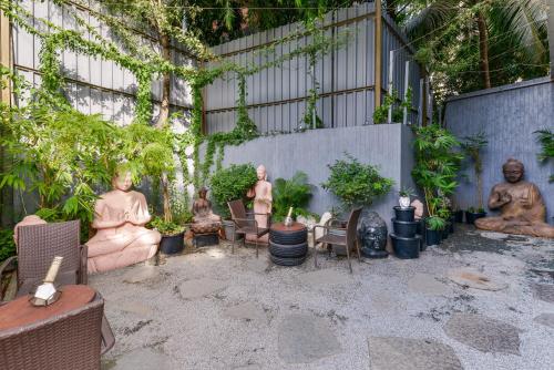 a courtyard with statues of people sitting on chairs at Dragonfly Hotel - The Art Hotel in Mumbai