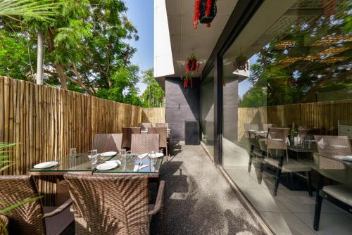 a restaurant with tables and chairs and a fence at Dragonfly Hotel - The Art Hotel in Mumbai
