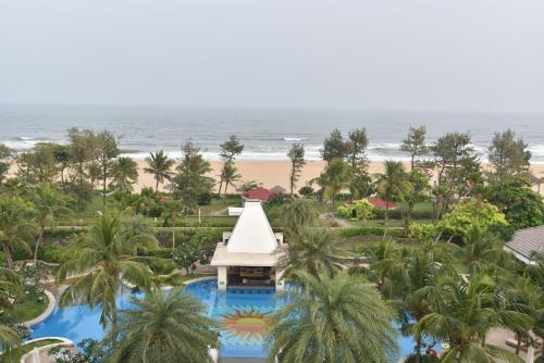 a beach with palm trees and palm trees at Taj Fisherman’s Cove Resort & Spa, Chennai in Mahabalipuram