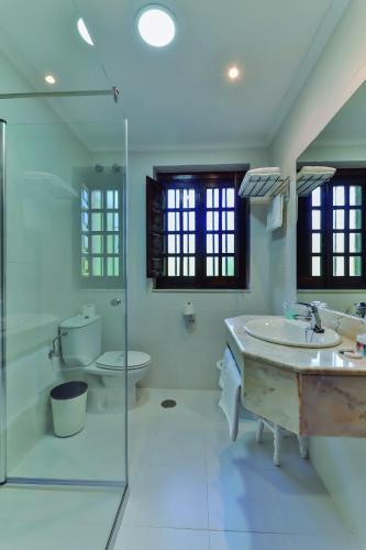 Un baño con dos lavabos y una ducha y un inodoro. en Hotel Santillana, en Santillana del Mar