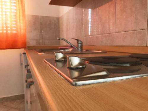 a kitchen counter with a sink and a stove at Apartment & Rooms Riva in Vodice
