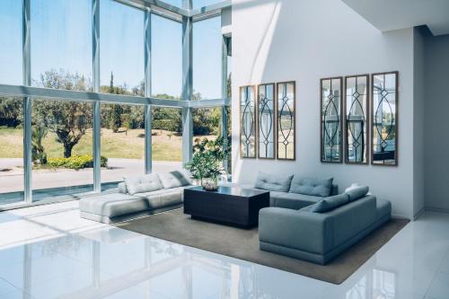a living room with couches and a table and windows at Iberostar Selection Lagos Algarve in Lagos