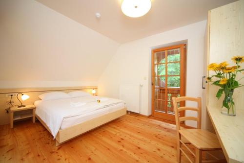 a bedroom with a bed and a table and a window at Planinski dom Savica in Bohinj