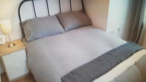 a small bed in a room with a lamp at CROMER FLAT ABDUL in Cromer