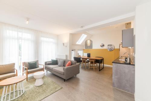 a living room with a couch and a table at Dormio Resort Maastricht Apartments in Maastricht
