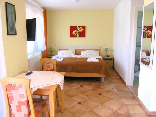 a bedroom with a bed and a table and a table and chairs at Apartments Kristina in Krk