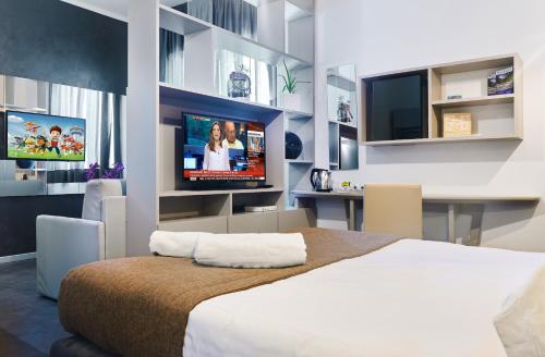 a bedroom with a bed and a flat screen tv at Hotel La Battigia in Alcamo Marina