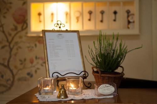 a table with a sign and candles and a potted plant at Villa Estera - Hotel & Restauracja in Michałowice