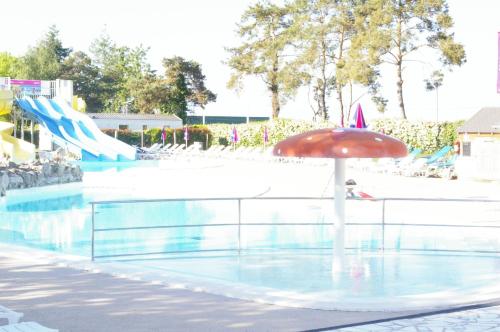a pool with an umbrella and a water slide at BVCO LOCATIONS PROCHE CHATEAUX ET BEAUVAL DANS LE LOIR et CHER in Onzain