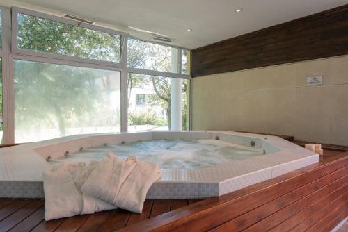a large soaking tub in a room with a large window at Tunkelen Carilo in Carilo