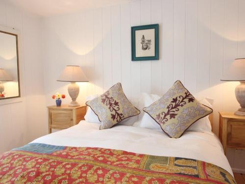 a bedroom with a bed with two pillows on it at Pegs in Porthleven