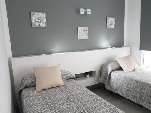 sypialnia z 2 łóżkami i zagłówkiem w obiekcie Vivienda Aries w Puerto del Carmen