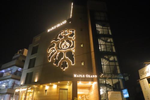 a building with a sign on the side of it at Maple Grand in Agra