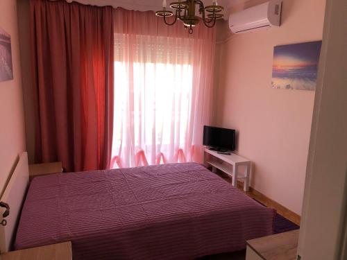 - une chambre avec un lit et une fenêtre avec une télévision dans l'établissement Del Mar Apartments II, à Agia Triada