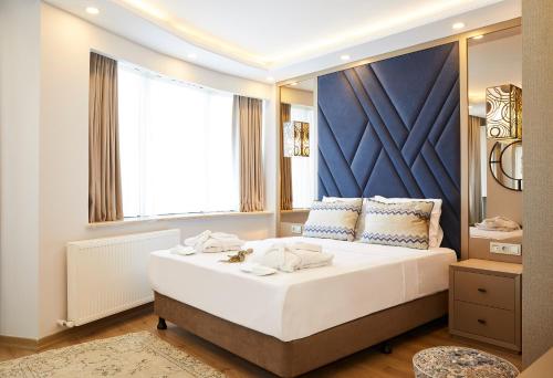 een slaapkamer met een groot bed en een groot raam bij All Seasons Suites in Istanbul