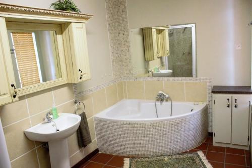 a bathroom with a tub and a sink at The Well guesthouse/Retreat in Kroonstad