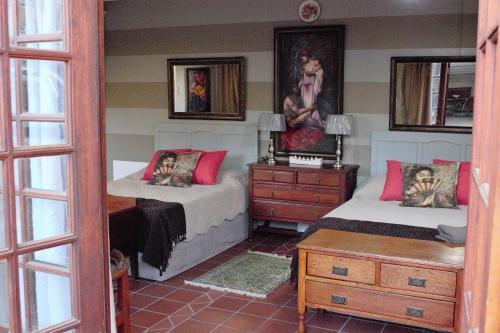 a bedroom with two beds and a dresser at The Well guesthouse/Retreat in Kroonstad