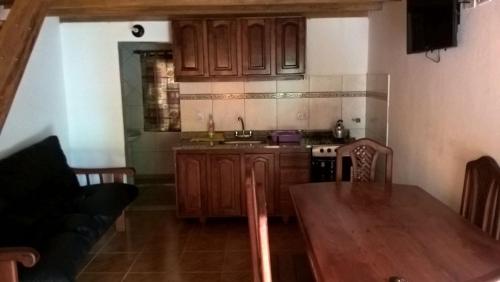 a kitchen with wooden cabinets and a wooden table with a dining room at Cedros in Puerto Iguazú
