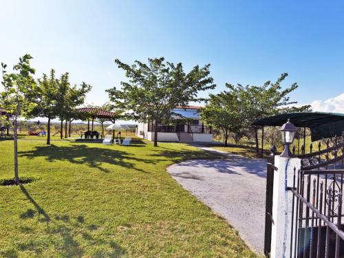 a white fence with a pathway next to a park at Mama's Twin Houses in Áyios Mámas