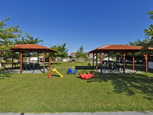 a park with a playground with tables and chairs at Mama's Twin Houses in Áyios Mámas